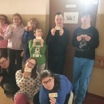 Grupa uczniów stoi przed drzwiami z napisem Sala 2. Wszyscy trzymają bilety do kina w rękach.