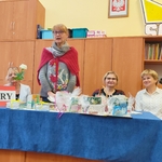 Trzy Panie zasiadające w jury obradują przy biurku.