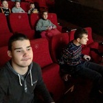 Grupa uczniów  siedzących w kinie.
