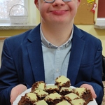 Uczeń trzyma talerz z piernikiem.
