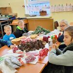 Uczniowie siedzą przy stole na którym znajdują się materiały potrzebne do zrobienia stoików bożonarodzeniowych.