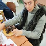 Uczennica układa szyszki na drewnianej bazie do stroików.