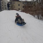 Dziewczyna zjeżdża z górki na jabłuszku.