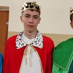Trzech uczniów w strojach króla niebieskiego, czerwonego i zielonego.