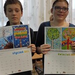 Uczeń i uczennica prezentują swoje prace plastyczne na kartkach kalendarza na rok 2023.