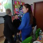 Uczniowie tańczą w kółko trzymając się za ręce.