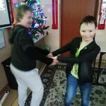 Dziewczynka i chłopiec tańczą trzymając się za ręce.