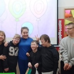Wychowawczyni z uczniami na tle tablicy z napisem 100 lat.