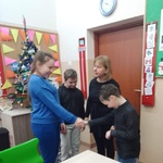 Nauczycielka i uczniowie składają życzenia jubilatowi.