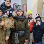 Grupa uczniów. Dwoje uczniów trzyma zegary w rękach.