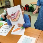 Uczennica prezentuje obrazek z niezdrową żywnością.
