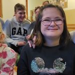 Trzy uczennice siedzące na ławce biorące udział w spotkaniu.