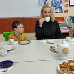 Dwie nauczycielki i uczniowie siedzą przy stole.