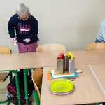 Uczeń i uczennica sprzątają stoliki po pracy.