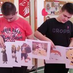 Dwóch uczniów  trzyma przypięte do drążków obrazki z postaciami z bajek.