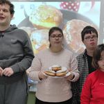 Grupa uczniów z talerzem pączków.