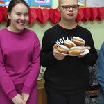 Grupa uczniów z talerzem pączków.