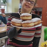 Uczennica z talerzem pączków.