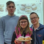 Trójka uczniów z talerzem pączków.