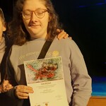 Laureatka trzyma przed sobą NAGRODĘ otrzymaną w konkursie.