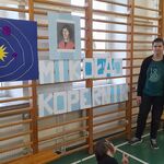 Uczniowie stoją obok dekoracji zawieszonej na drabinkach: portret Mikołaja Kopernika, duży napis -Mikołaj Kopernik, układ planet.