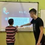 Uczniowie rozwiązują zadanie na tablicy interaktywnej.