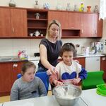Uczennica sypie mąkę do miski.