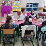 Grupa uczniów siedzi wokół stołu.