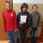 Trzech uczniów z torbą słodyczy.