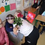 Chłopiec składa życzenia dziewczynce siedzącej na krześle.