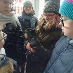 Uczniowie patrzą na but trzymany w dłoni koleżanki.