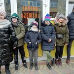 Grupa uczniów przed zakładem szewskim.