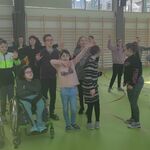 Duża grupa uczniów w trakcie nauki tańca grupowego.