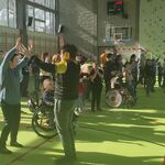 Duża grupa uczniów w trakcie nauki tańca grupowego.