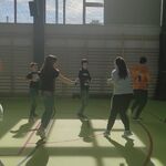 Grupa uczniów w trakcie nauki tańca w parach..