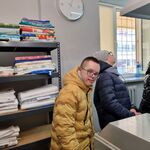 Grupa uczniów stoi przed maszyną do maglowania.