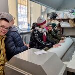 Grupa uczniów stoi przed maszyną do maglowania.