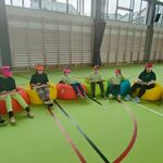 Cymbałkowa orkiestra: 8 uczniów siedzi na pufach. Na kolanach trzymają cymbałki i grają wiosenną piosenkę.