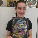 Uczennica prezentuje swoją pracę plastyczną.