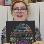 Uczennica prezentuje swoją pracę plastyczną.