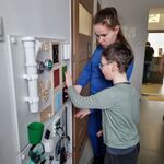 Dwoje uczniów dotyka tablicy sensorycznej.