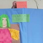 Parawan z napisem Teatrzyk nowalijkowy i postacią wiosny. Za parawanu wystaje ręka nauczycielki z kartką z napisem szczypiorek ii szczypiorek.