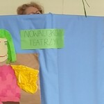 Parawan z napisem Teatrzyk nowalijkowy i postacią wiosny. Za parawanu wystaje głowa nauczycielki i szczypiorek.