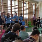 Panie prowadzące zajęcia pierwszej pomocy przedmedycznej oraz uczniowie siedzący na ławeczkach.