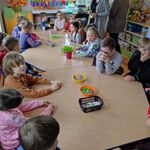 Grupa dzieci siedzi wokół stołu.