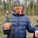 Uczeń z sadzonką drzewka w ręku.