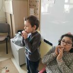 Dwójka dzieci dmucha w urodzinową trąbkę.