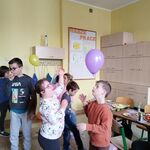 Grupa dzieci odbija baloniki.