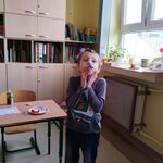 chłopiec dmucha w trąbkę urodzinową.