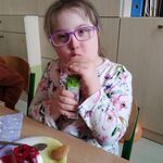 Dziewczynka pije sok z kartonika przez słomkę.